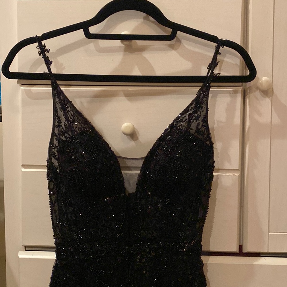 Short body con dress in the color black. Has a patterned sequence. Worn twice.